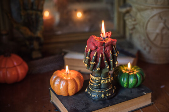 Burning heart candle held by witch hands on magical altar for love spells, cleansing negative energy and romantic rituals 