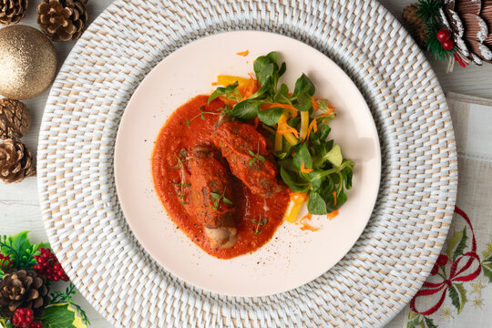 Cheese-stuffed veal roll with tomato sauce. Top-down view. Traditional Christmas recipe.