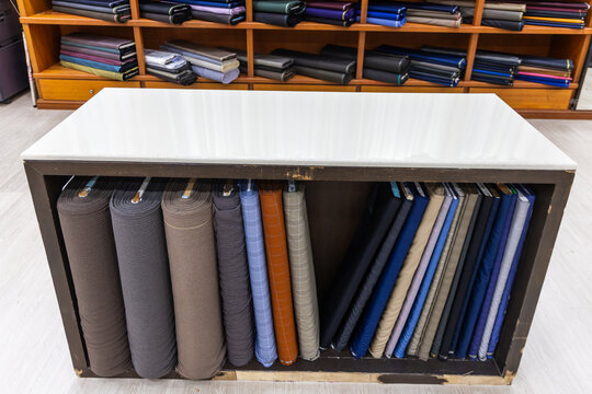 Close-up of classic traditional generic bespoke tailoring cutting table and bolt of fabric cloths. Perfect to be used as background