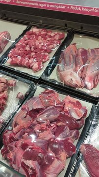 raw fresh beef meat displayed in plastic packaging inside a refrigerated supermarket display case