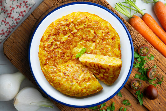 Spanish potato omelet tapa with a slice cut out. Top-down view. 