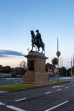 Historic equestrian monument of a military figure on horseback standing at urban road intersection