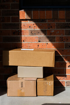Cardboard boxes piled outside door of house from online home delivery orders