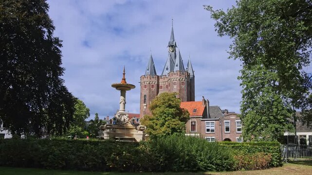 Historic Sassenpoort city gate rising behind a decorative fountain and lush park trees in Zwolle, Netherlands on 23 August 2026.