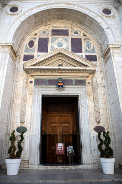 Antico portale d'ingresso in marmo della facciata del Tempio Malatestiano a Rimini con grande porta in legno, decorazioni geometriche rinascimentali e piante ornamentali ai lati