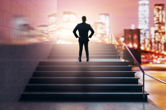 Businessman standing on staircase toward success and growth above a glowing city skyline at night, symbolizing career direction, ambition, and new opportunity.