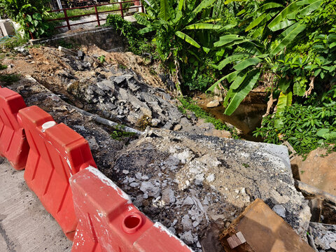 Road construction site with open trench and safety barriers