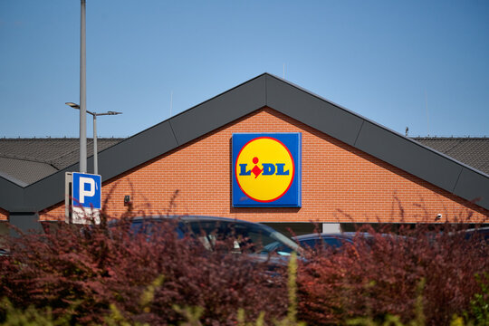 Exterior view of a Lidl supermarket store facade with the corporate brand logo against a blue sky in Gdansk, Poland