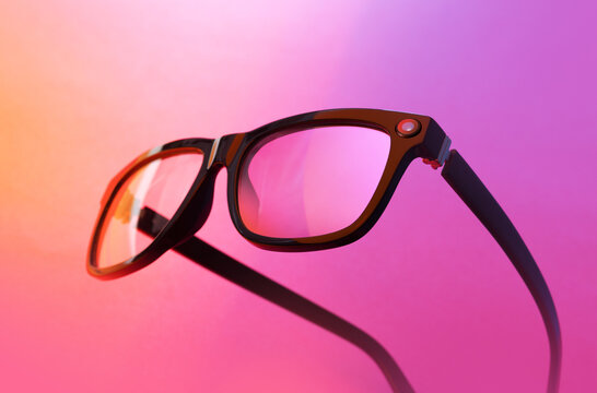 Smart glasses with built-in camera lens illuminated by gradient lighting
