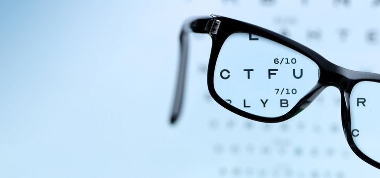Black Eyeglasses Focusing Letters on Eye Test Chart for Vision Examination