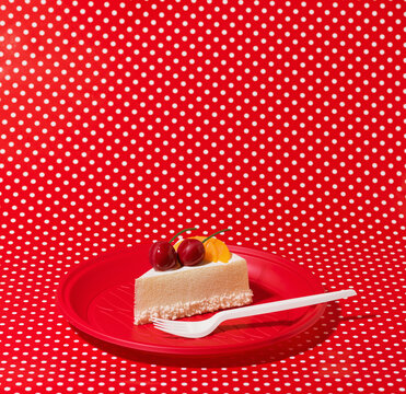 Slice of Fruit Birthday Cake on Red Disposable Plate