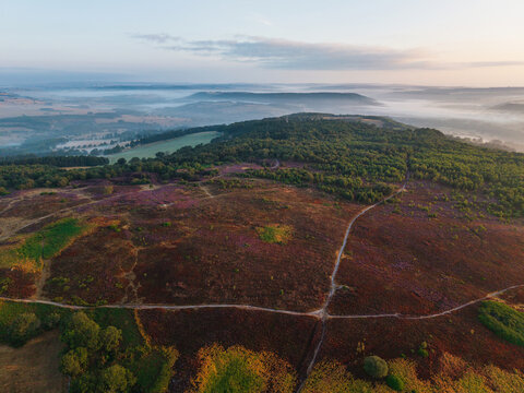 Beautiful drone landscape image over Stanton Moor in Summer Heather sunrise
