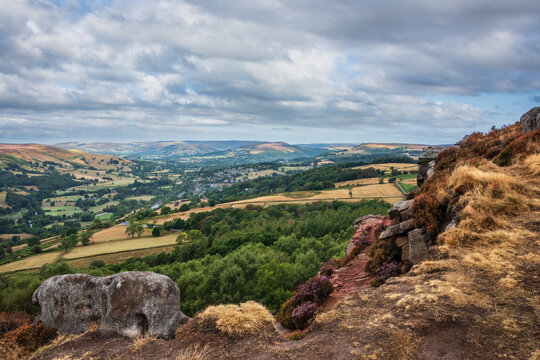 Stunning Peak District landscape from Surprise View with vibrant heather and dappled sunlight over the hills