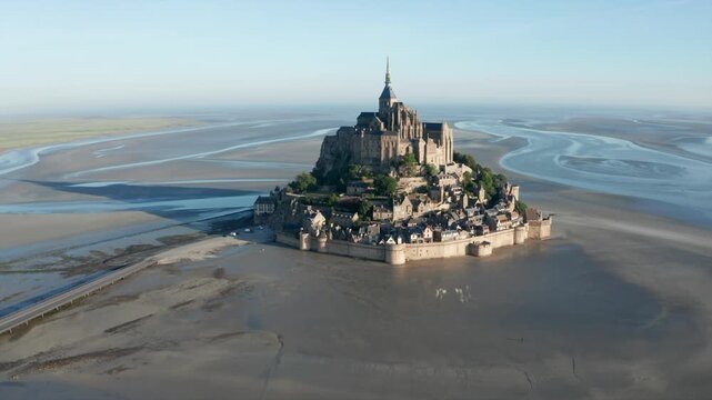 Aerial view of Mont Saint-Michel abbey surrounded by tidal flats, France.