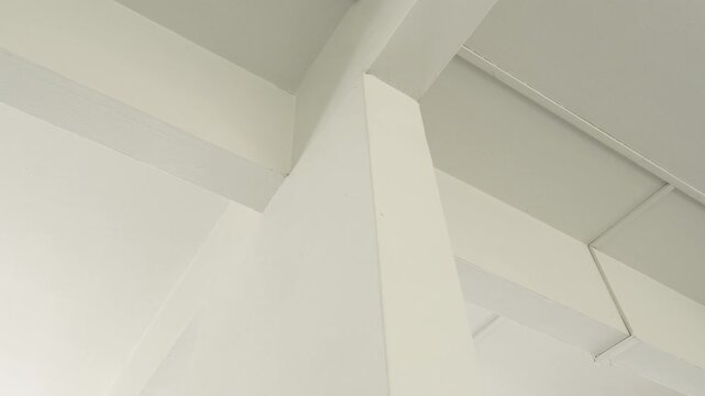 Clean minimalist white architectural interior corner with abstract geometric lines.