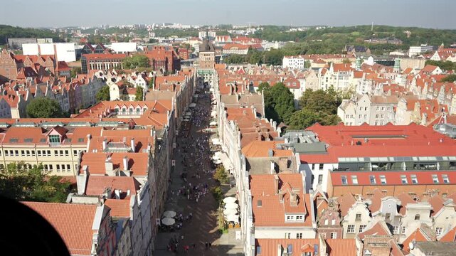 Top down aerial view of a European old town with red tiled rooftops colorful facades and a busy street below