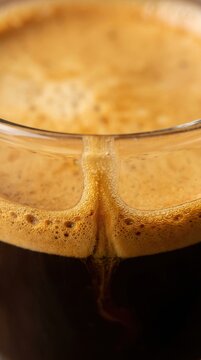 Rich espresso with thick golden brown crema in a glass cup