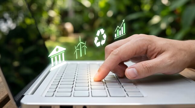 Human hand typing on silver laptop outdoors with glowing green ESG icons representing wind power and sustainable investing for corporate responsibility concept.