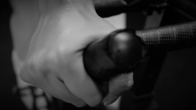 Close Up Black and White Fast Pedaling Action on Indoor Spinning Bike at Gym