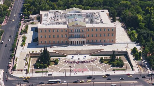 High-angle drone perspective of the historic Hellenic Parliament and Syntagma Square in Athens, Greece, showcasing the famous landmark and the vibrant city traffic flowing below