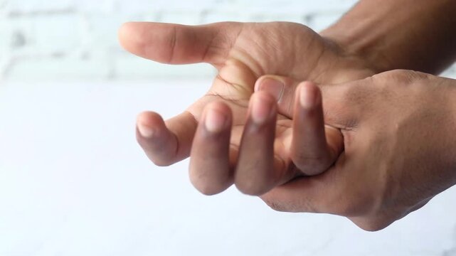 Close-up of hands massaging palm to relieve pain or discomfort