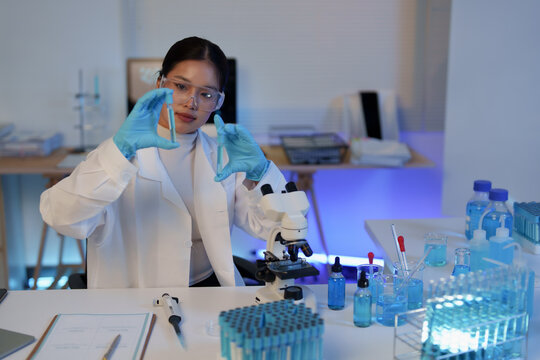Young female scientist researching innovative drug formulations and vaccine development, examining samples in a biochemistry laboratory with advanced equipment for medical science
