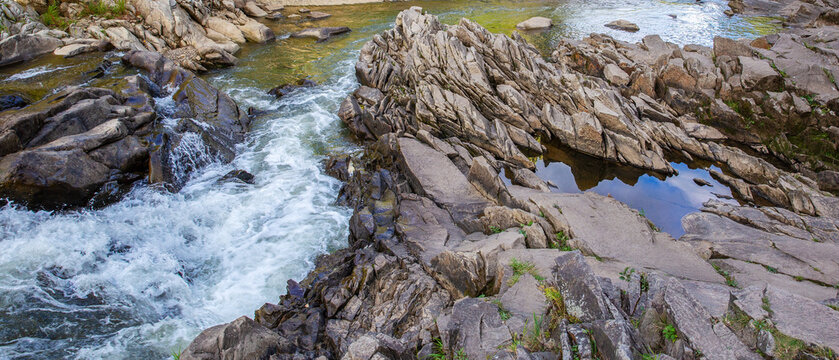 Mountain river stream flowing over flat rocks texture background