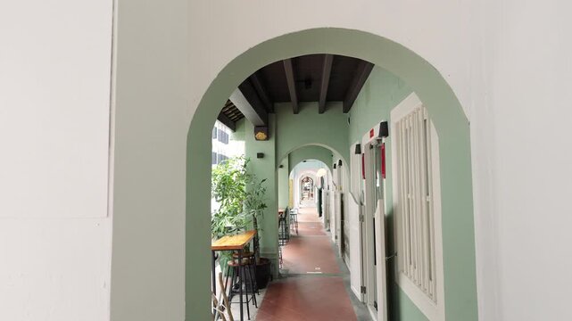 Historic arched corridor with green trim in a heritage building in Singapore.