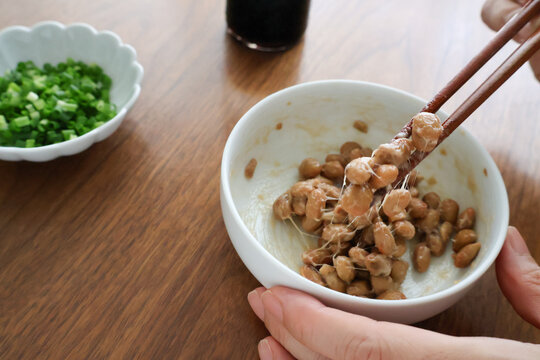 食卓で納豆をお箸で食べる手元のアップ