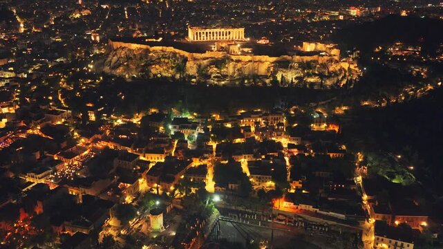 Stunning aerial footage of Athens at night, capturing the ancient Acropolis and the iconic Parthenon beautifully illuminated against the glowing cityscape, a symbol of Greece's rich history