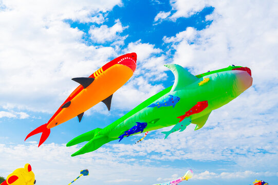 Flying colorful kites in blue sky with clouds. Kite festival. The concept of freedom