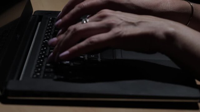 Close-up view of female hands typing on a laptop keyboard in a modern business office, illustrating professional work, technology, productivity, and digital communication