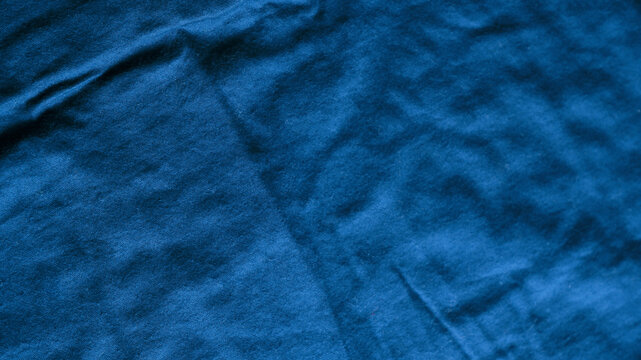 Blue fabric with crumpled texture background. Abstract texture background of top view deep blue fabric. Concept of crease, wrinkled cotton, organic, cloth, woven, indigo, denim for textile design, bac