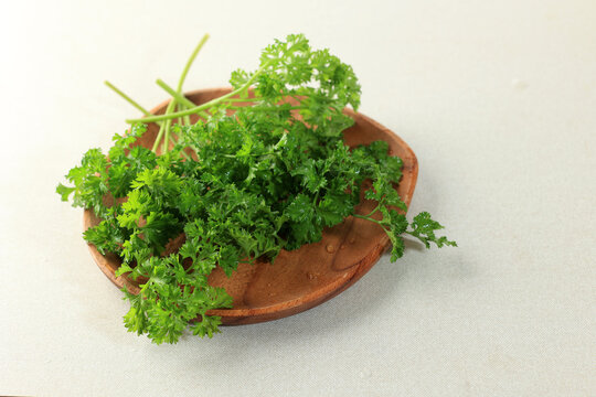 Fresh parsley on a rustic wooden plate.