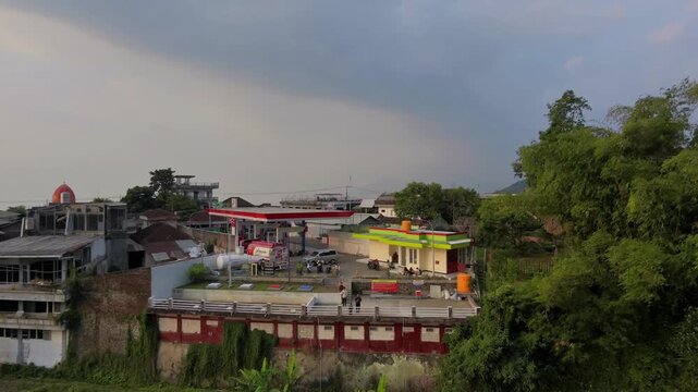 Aerial View of Gas Station and Rest Area on Hillside with Town Background