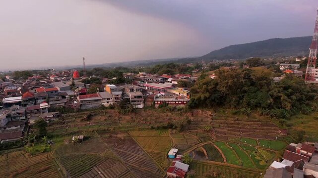 Aerial Drone of Rural Town, Farmland and Mountain Under Cloudy Sky