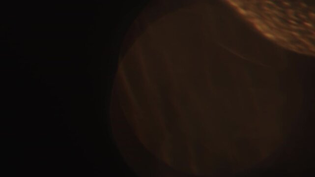 Slow motion real lens flare from back sunlight over dark background for overlay