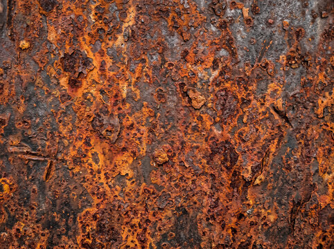Industrial rusty metal texture featuring orange corrosion and weathered iron surface details