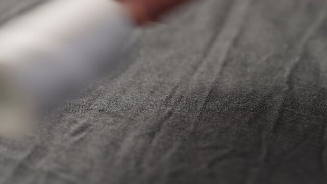 Slow motion man manually check gray color cotton fabric for clothing with hands