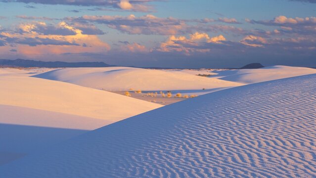 View of White Sands National Park with gypsum sand dunes under a sunset sky in New Mexico, United States.