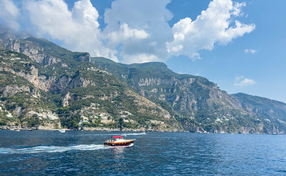 Small Passenger Boat Sailing Along a Mountainous Mediterranean Coast in Italy