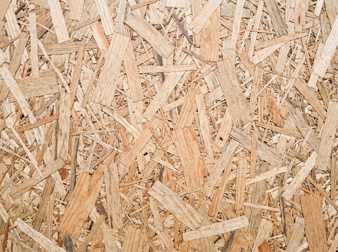 Textured OSB board background featuring compressed wooden flakes in natural beige tones