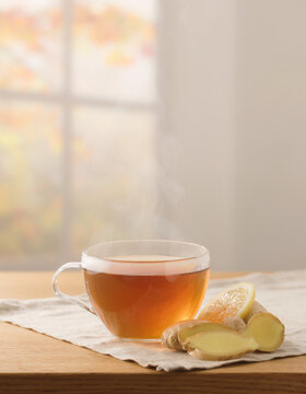 Warm ginger tea with lemon in clear glass cup