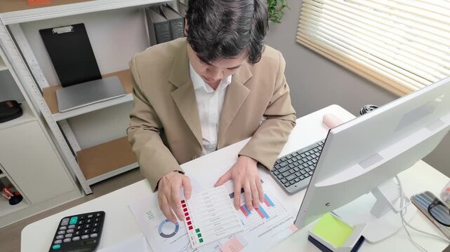 Professional businessman reviewing financial report at office desk, business plan checklist, corporate presentation stock footage