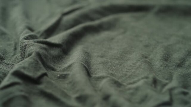 Slow motion man hand cleaning green linen jersey cloth