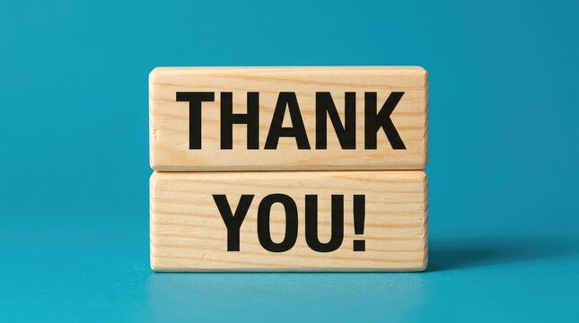Wooden blocks spelling out thank you on a teal background gratitude concept