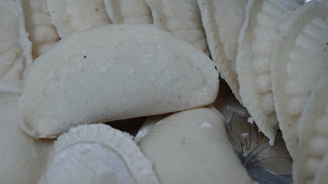Close-up of fresh white Puli pitha stacked together, showing soft texture and natural patterns