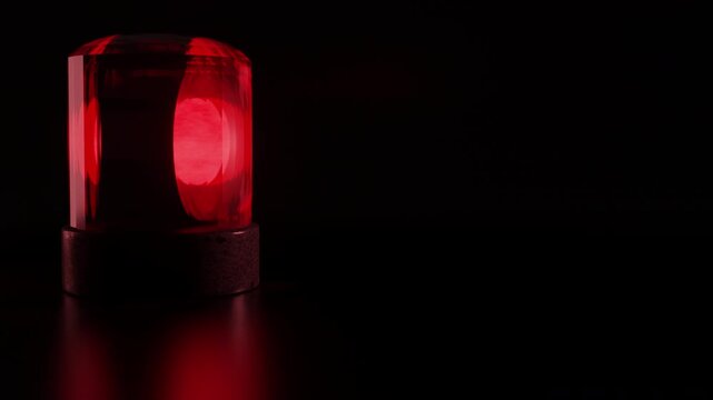 Spinning beacon. A 3D render of a red emergency siren light rotating on a dark background, indicating urgent alerts, security breaches, or crisis situations. 4K high quality footage.