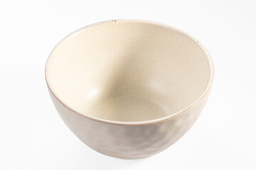Empty beige ceramic bowl with speckled texture on white background, shallow depth of field, soft...