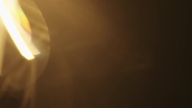 Slow motion real lens flare from back sunlight over dark background for overlay
